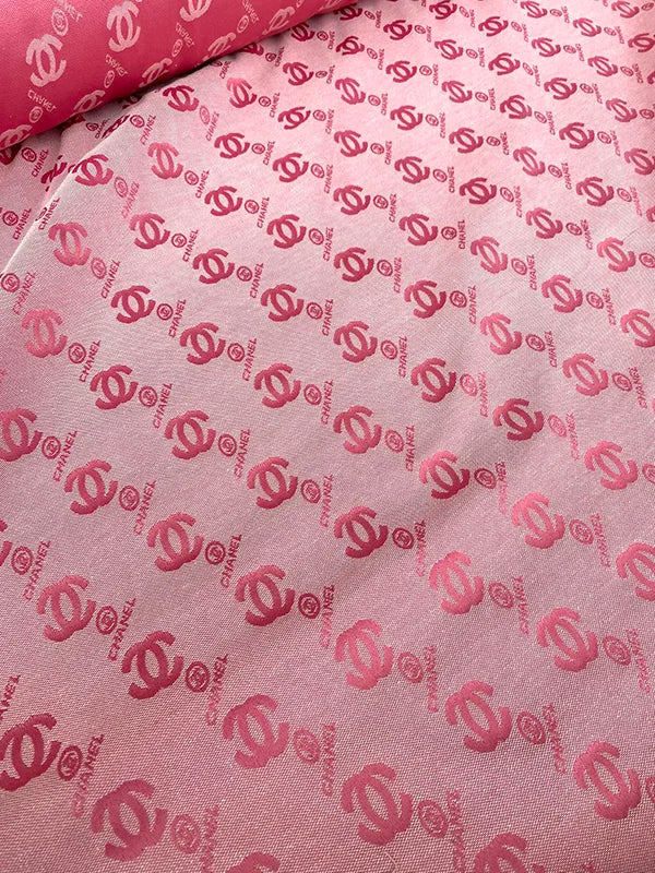 Pink fabric with red Chanel logo pattern