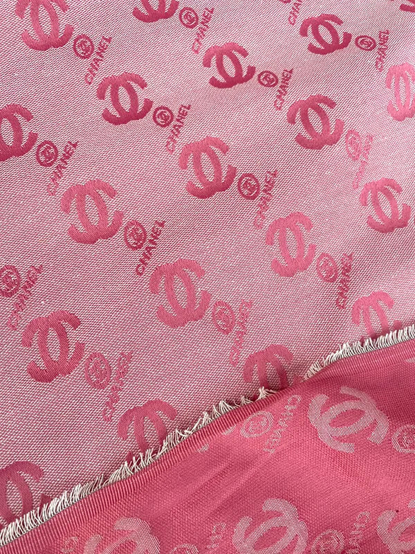 Pink fabric with red Chanel logo pattern
